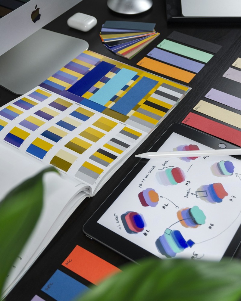 Brand identity design workspace with logo sketches and color systems for a growing business